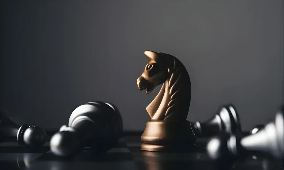 Monochrome image of a black knight chess piece standing upright among fallen pawns on a chessboard. Dramatic contrast and a contemplative tone.